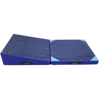 Plan incliné pliable en mousse, recouvert d'un revêtement en tissu bleu, avec une surface inclinée à une extrémité et une partie plate de l'autre, idéal pour l'entraînement en jonglerie et d'autres exercices.