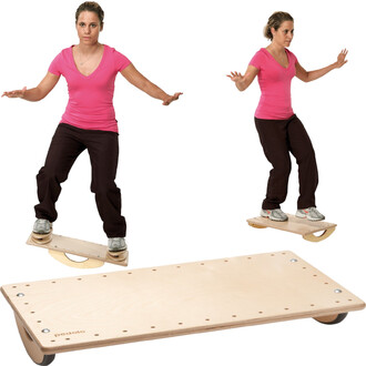 Pedalo® 600 K70, tavola basculante con una persona in equilibrio sulla tavola, braccia estese ai lati per la stabilità. La tavola è realizzata in legno, con una sezione inclinata e una base solida. I dettagli sulla superficie della tavola sono