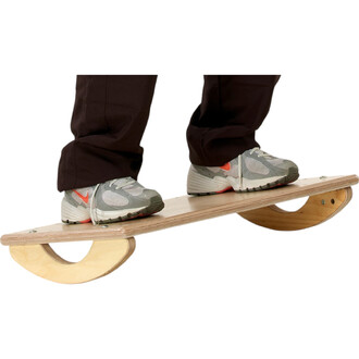 Un individu se tient debout sur un équilibre de bois, avec les pieds posés sur la planche. Le plateau est soutenu par deux courbes en bois, offrant une surface instable. Le participant porte des chaussures de sport grises avec des accents orange, et des p