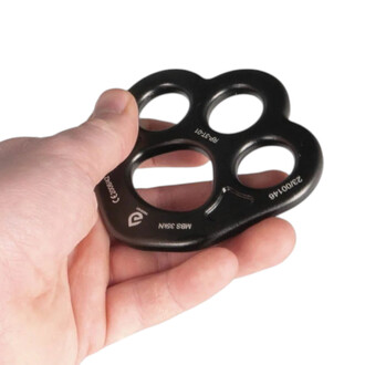 Plaque d’ancrage aérienne Prodigy en métal noir à quatre trous, forme de trèfle, tenue dans la paume d’une main.