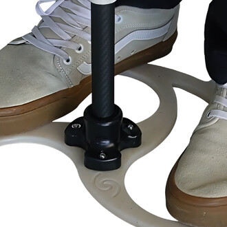 Pied chaussé d'une sneaker beige sur un support en forme de spirale avec une tige noire centrale. Le fond est blanc pour mettre en valeur le produit.