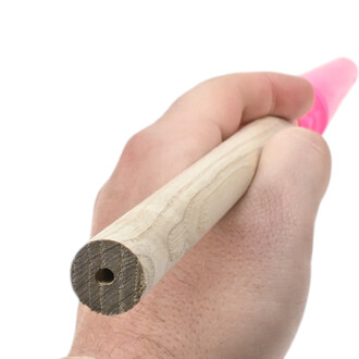 Poignée Delphine courte en bois clair tenue dans une main, avec embout rose en silicone à l’extrémité.
