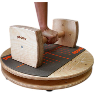 Équipement de jonglerie avec une plateforme en bois de forme ronde, dotée d'un tapis de pratique en silicone, et d'une barre de maintien en bois avec des poids. La main d'un utilisateur saisit la barre, qui comporte des poids en bois numérotés.