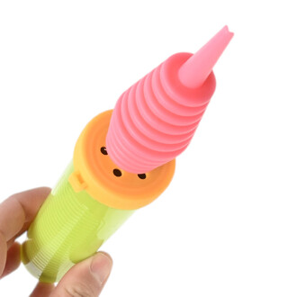 Pompe double action Pocket Balloon, embout rose et corps vert fluo, vue de près tenue par une main.