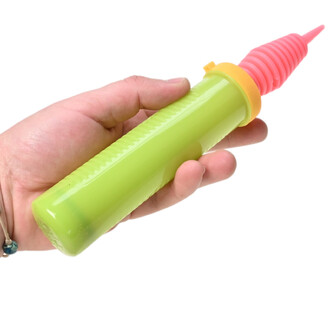 Pompe à ballons double action Pocket Balloon : corps vert lime, embout rose spiralé et collerette orange, tenue dans une main.