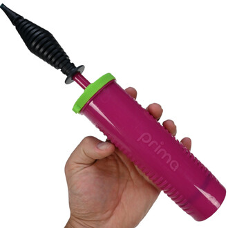 Pompe à main double action de couleur rose avec un embout noir. La pompe est tenue par une main et possède un couvercle vert.