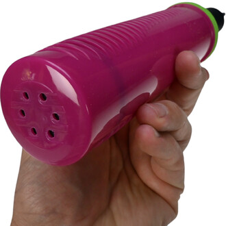 Pompe à main double action de couleur rose tenue dans une main, montrant la base avec plusieurs orifices pour le gonflage.
