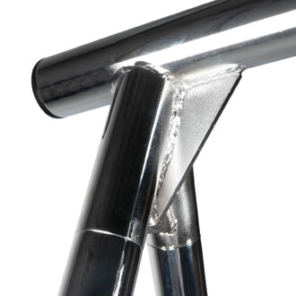 Détail d'une fixation en métal du portique de yoga, mettant en avant des tubes en acier chromé, un joint de soudure et une finition polie.