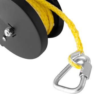 Détail d'un système de poulie avec une corde jaune enroulée sur un tambour noir, et un mousqueton en métal attaché à la corde.