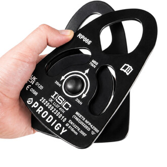 Poulie large noire ISC Prodigy RP066 tenue en main, vue rapprochée sur le marquage technique : référence RP066, charge de rupture MBS 70kN, charges de travail 35kN, normes NFPA2500 et EN12278, et logo de la marque.