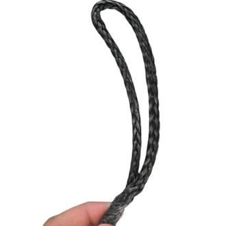 Rope Dart Feu ISIS, vue d'un cordon noir tressé tenu à la main, enroulé sur lui-même, prêt à être utilisé pour la jonglerie avec effet de feu.