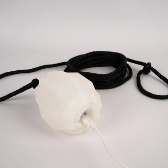 Rope Dart LED Prism de Threeworlds, avec une tête en forme de prismatique blanche et un cordon noir enroulé. Le produit inclut un câble d'alimentation connecté à la tête.