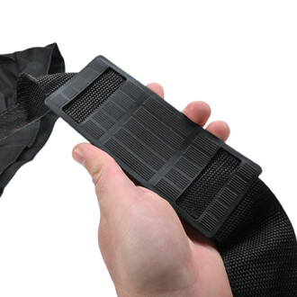 Gros plan sur une sangle noire réglable en nylon avec boucle en plastique, tenue par la main, pour le Sac à Ballons.