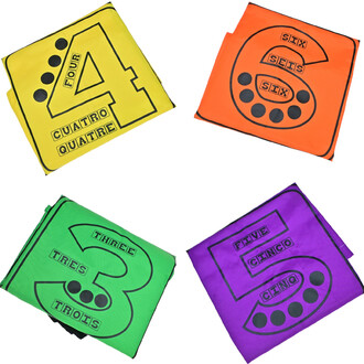 Quatre sacs à sauter de couleurs vives : un sac jaune avec le numéro 4, un sac orange avec le numéro 6, un sac vert avec le numéro 3 et un sac violet avec le numéro 5. Chaque sac comporte des inscriptions en plusieurs langues indiquant le chiffre et une r