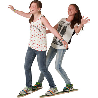 Deux jeunes filles s'amusent à se tenir en équilibre sur une planche de jonglerie. Elles sont habillées de t-shirts décontractés et portent des jeans. Les filles affichent des sourires joyeux et ont les bras levés pour garder leur équilibre. Des chaussure