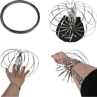 Sculpture cinétique en fils métalliques argentés : bobine de fil, sphère d’anneaux métalliques et sac de rangement noir, démontrant une main et un avant-bras entourés par les anneaux.