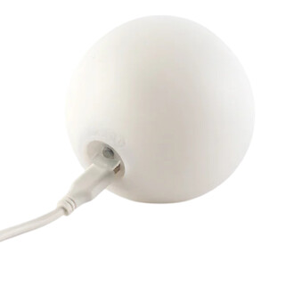 Balle LED Lumi Pro de couleur blanche avec un cordon de chargement branché, vue rapprochée sur la prise.