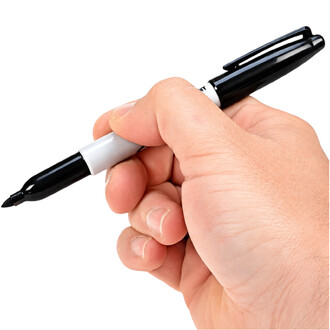Gros plan d'un marqueur Sharpie noir tenu par une main avec la pointe feutre exposée, contre fond blanc.
