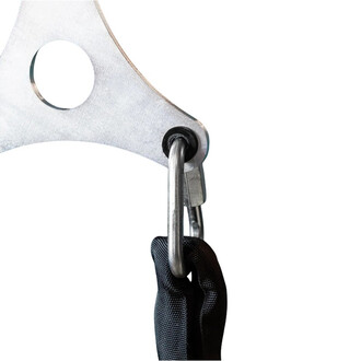 Detalhe do dispositivo de fixação Smart Rope: placa triangular de metal com ilhó grande, mosquetão de aço e fita de náilon preta, segurada por uma mão enluvada.