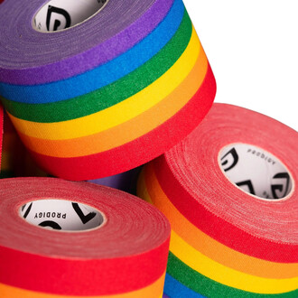 Three rolls of Prodigy rainbow-colored tape stacked on top of each other, with a main roll showing multicolored stripes and two other red rolls underneath bearing the inscription