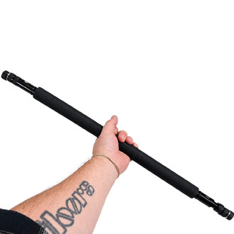 Main d'une personne tenant un staff contact Fusion Feu Threeworlds de 150 cm, bâton noir avec grip texturé et embouts compatibles avec des mèches de feu.