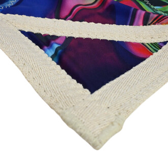 Détail du bord du Disque Flying Star, montrant la couture en tissu beige et le design coloré en arrière-plan, avec des motifs abstraits dans des teintes violettes et vertes.