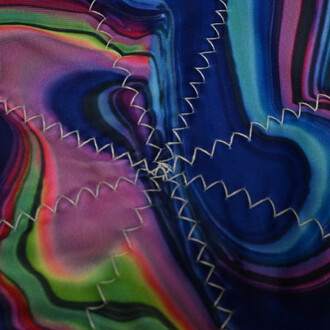 Texte coloré et texturé du disque Flying Star, présentant des motifs fluides en violets, bleus, verts et roses, avec des détails de couture blanche sur les bords.