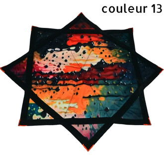 Disque volant Flying Star coloré et souple, patchwork multicolore en forme d’étoile à huit pointes avec bordures noires et coins orange.