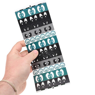 Planche de stickers Yeux : rangées d’yeux cartoon sur fonds turquoise, noir et gris, tenue par une main.
