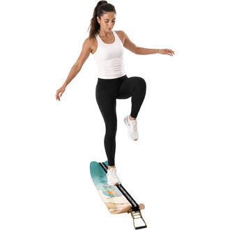 Femme sportive debout sur une Surfline Balance Board F2 turquoise, en équilibre sur une jambe, bras écartés, vêtue d’un débardeur blanc et legging noir, fond blanc.