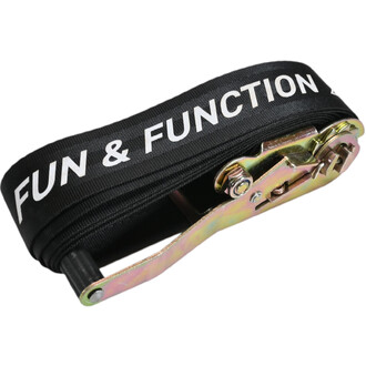 Gros plan sur une sangle noire imprimée “FUN & FUNCTION” avec boucle et plaque métallique dorée, accessoire du Surfline Balance Board F2.