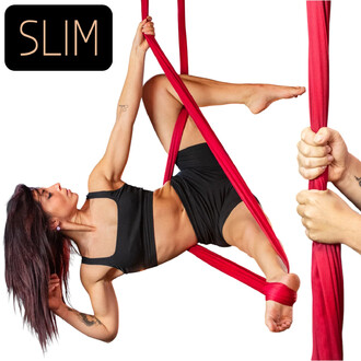 Femme en position aérienne sur un tissu rouge Slim, avec une main tenant le tissu et une jambe enroulée autour de celui-ci, le tout sur fond blanc. Logo SLIM en haut à gauche.