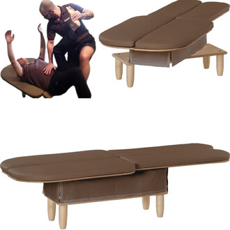 Table de massage pliable avec un revêtement marron, présentée en trois vues : une vue de face montrant la table vide, et une vue en action où un praticien effectue un soin sur un client allongé. Les pieds en bois sont visibles et la table comporte un rang