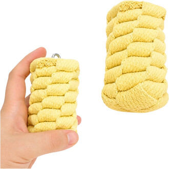 Gros plan d’une tête de bolas Twista en corde jaune torsadée avec un petit anneau métallique, tenue par une main au premier plan sur fond blanc.