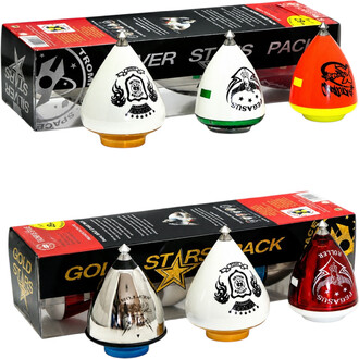 Confezione da 3 trottole coniche colorate per giocoleria, con motivi neri e punta metallica, presentate con la loro confezione nera e rossa sullo sfondo.
