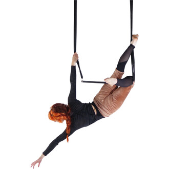 Personne suspendue sur le Trapèze Prodigy Polysafe, en position horizontale, bras et jambes étendus, tenant une barre centrale avec des sangles noires.