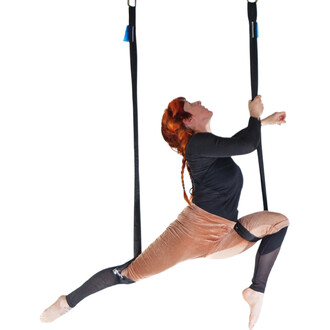 Trapèze Prodigy Polysafe suspendu avec sangles noires; personne effectuant une figure, vêtue d’un haut noir et d’un pantalon beige.
