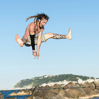 Crazy jump off slacklines with the sea in the background