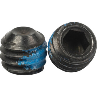 Deux vis sans tête Dragon bleues et noires en gros plan, montrant les extrémités arrondies et l’alésage hexagonal à l’intérieur.
