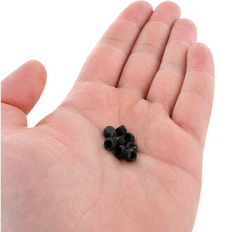 Kleine schwarze Kunststoffschraubenteile, die in der Handfläche gehalten werden und für den Drachenstab Gora bestimmt sind.
