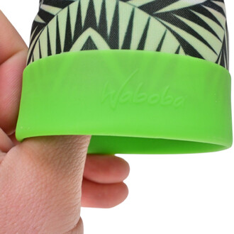 Main tenant un produit Waboba Airlyft avec un fond en silicone vert et un motif graphique noir et crème.