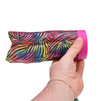 Main tenant un Waboba Airlyft, un accessoire de jonglerie avec un motif coloré inspiré d'un zèbre sur le corps souple et un bord en plastique rose.