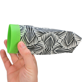 Un joueur tient un Waboba Airlyft, un accessoire de jonglerie, dans sa main. L'objet a une forme allongée et est décoré avec un motif géométrique en noir et blanc, tandis que l'embout supérieur est vert.