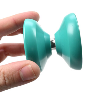 Gros plan d’un yo-yo Skyva turquoise tenu entre les doigts, montrant les deux coques rondes et l’axe métallique.