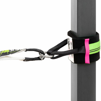 Sangle de slackline verte et noire attachée à un poteau avec un manille métallique, montrant une installation sécurisée et stable utilisant les composants du Kit Indoor Slackline de Spider Slacklines