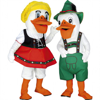 Costumes de mascottes représentant un canard et une cane, habillés en vêtements colorés. La cane porte une robe rouge avec un corsage noir, tandis que le canard est vêtu d'un pantalon court vert et d'un chapeau vert. Les deux mascottes ont de grands souri