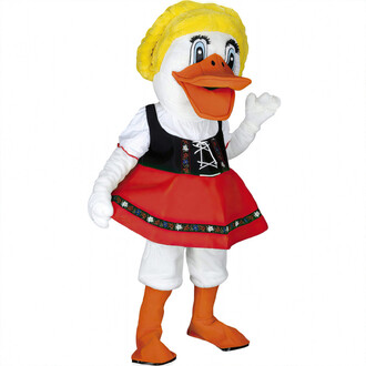 Mascotte en costume de canard debout, portant une robe rouge et un corsage noir avec des motifs colorés, et une perruque blonde. Elle a une grande tête de canard avec un large sourire et des yeux expressifs, tout en levant une main en signe de salut.