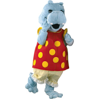 Mascotte Julie l'Hippopotame, costume en peluche bleu avec une robe rouge à pois jaunes, souriante et faisant un geste de la main. Elle porte un pantalon clair et des pattes en peluche, ajoutant une touche amusante et chaleureuse.