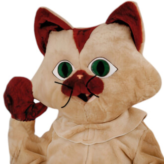 Mascotte Tikiwi le Chat, costume de chat en peluche de couleur beige avec des accents marron, grands yeux verts, et une expression amicale. La mascotte fait un geste de salut avec une de ses pattes.