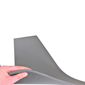 Mousse de gymnastique en couleur grise, présentée à une main qui tient un coin, mettant en avant sa texture et sa flexibilité.